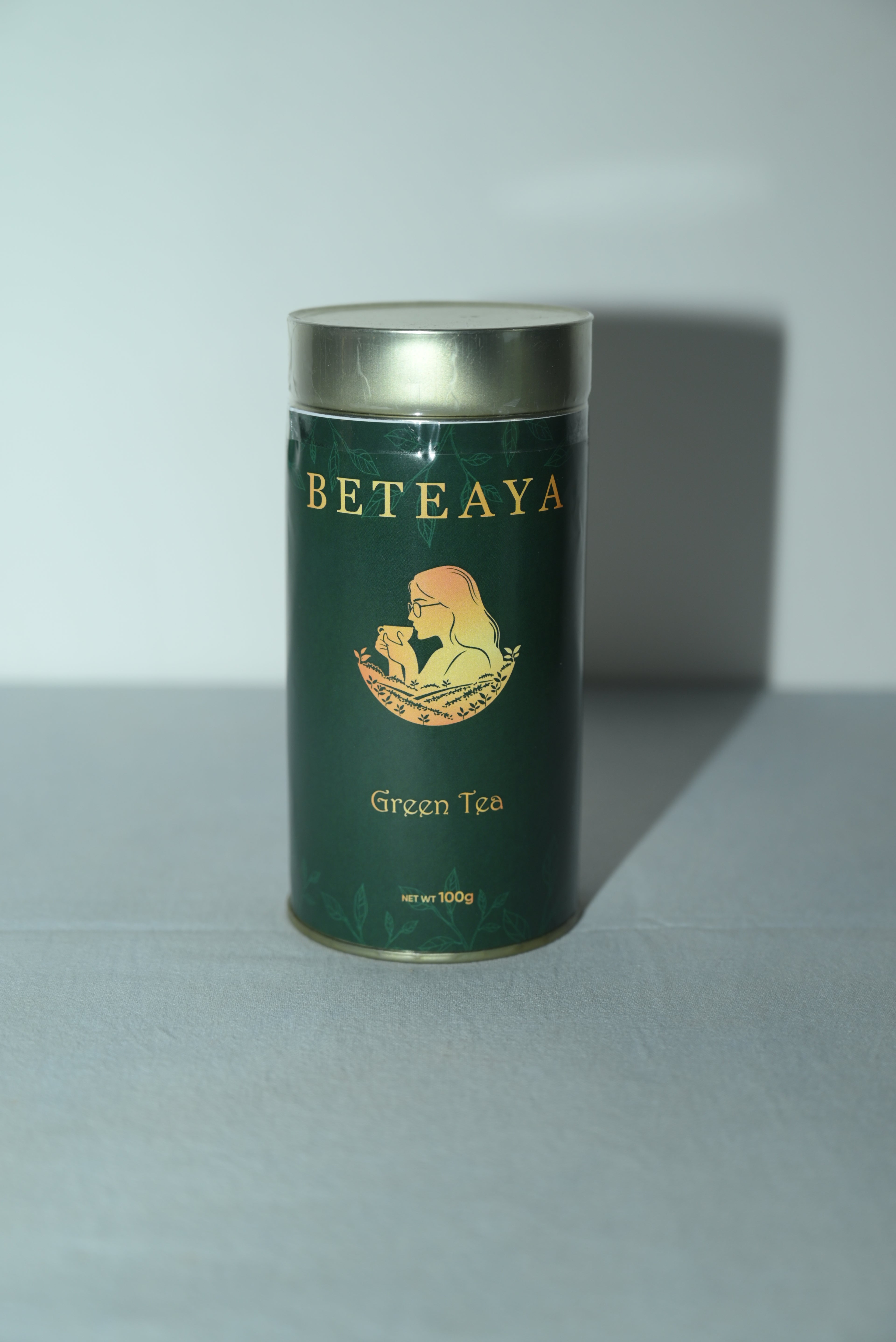 Green tea canister with 'Beteaya' branding on a light gray background